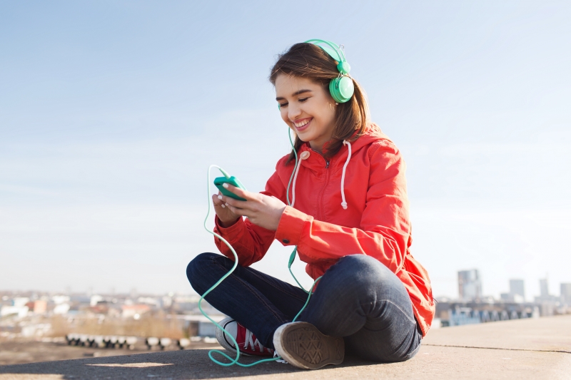 12205253-happy-young-woman-with-smartphone-and-headphones